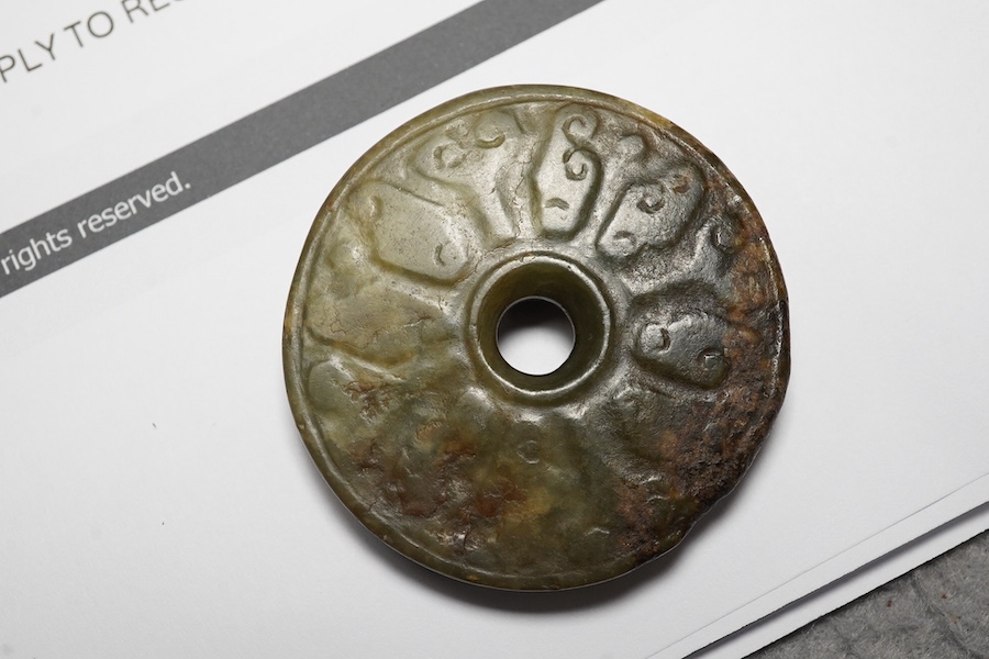 A Chinese green and brown jade bi disc, Yuan/Ming dynasty